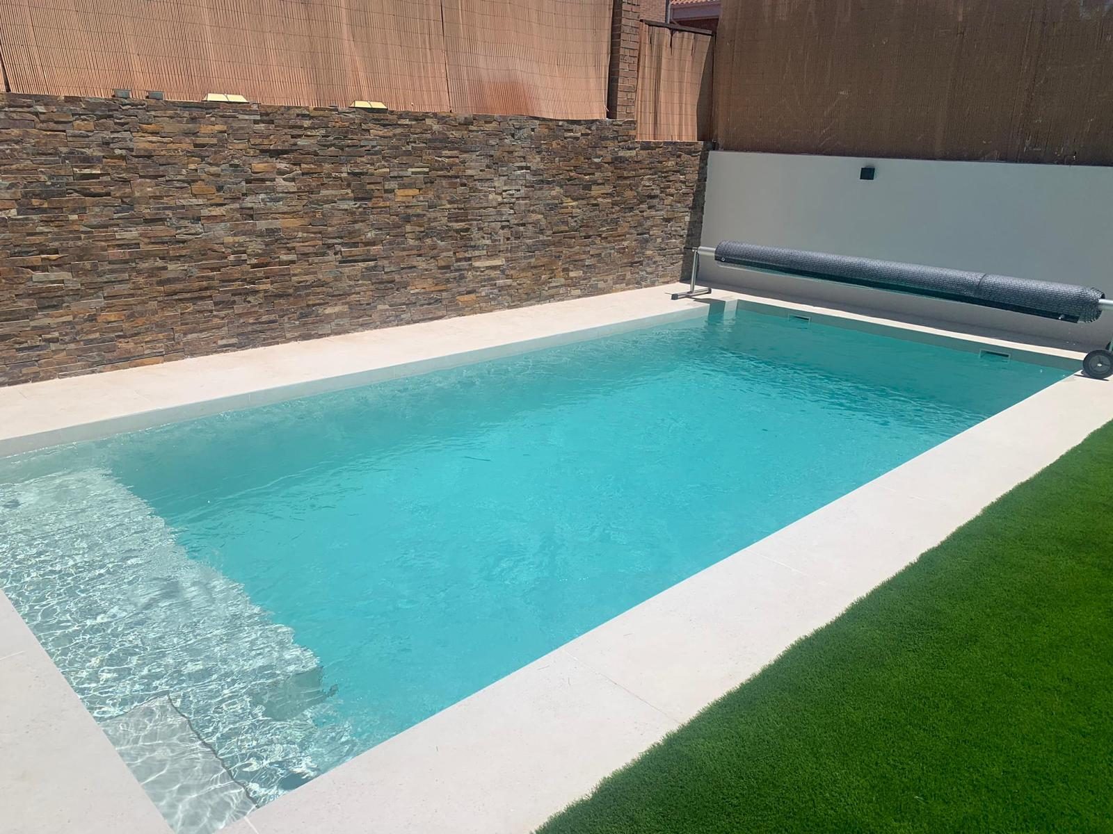 Piscina de gran formato con muro de piedra