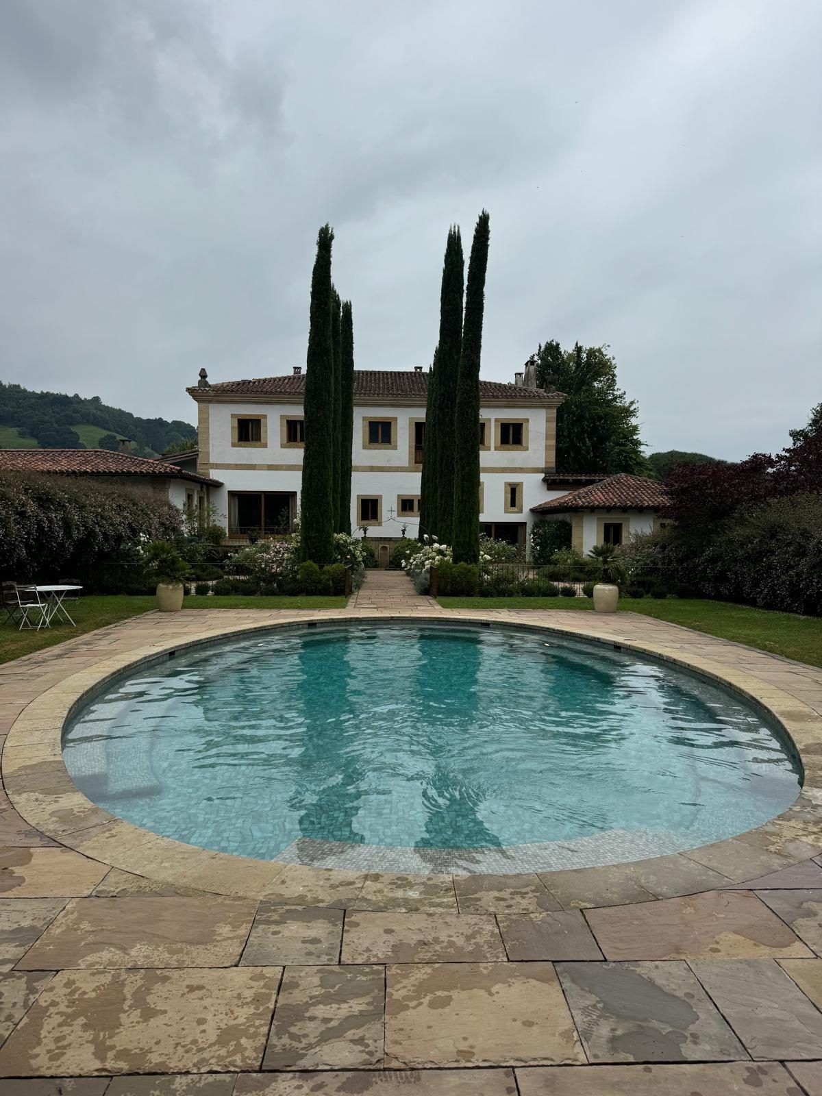 Piscina circular clásica con jardín