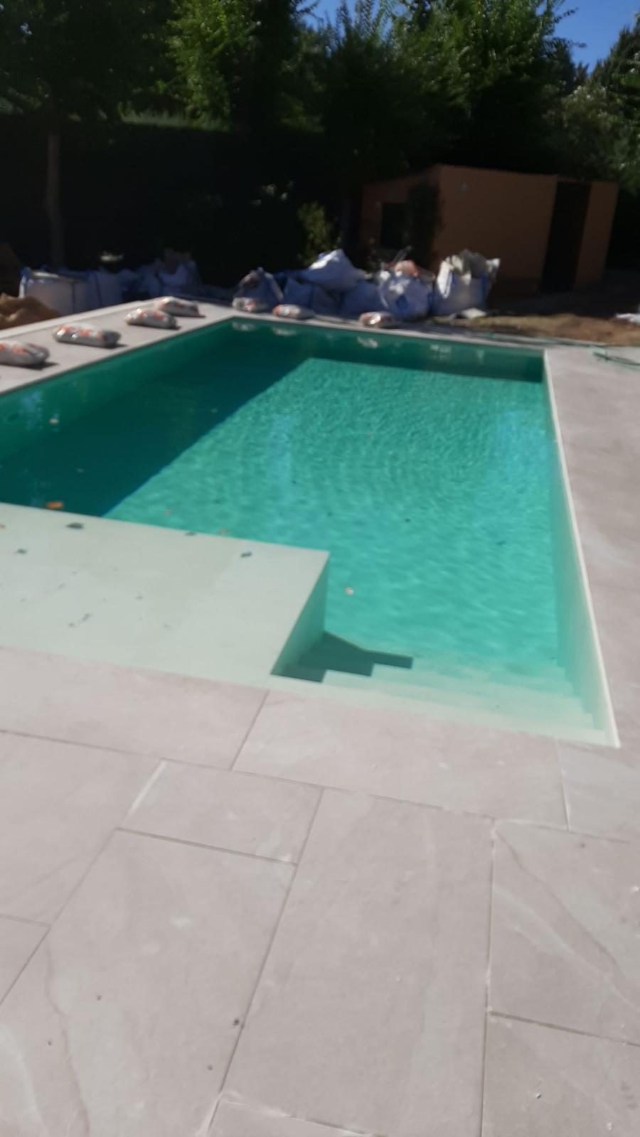 Piscina con zona de jardín y solárium