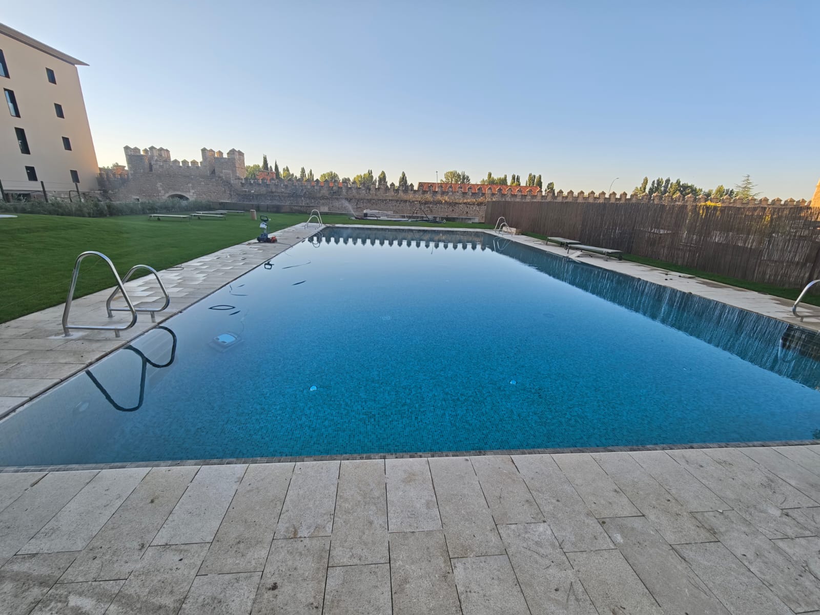 Gran piscina exterior desbordante con vistas a la muralla